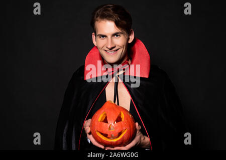 happy man holding halloween pumpkin isolated on black Stock Photo