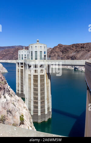 Penstock towers of the Hoover Dam with blue sky and blue waters of Lake Mead behind it Stock Photo