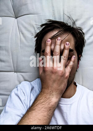 Exhausted Young Man on Bed - Frustrated Man Stock Photo