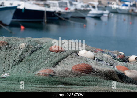 Fishing nets and colored buoys drying in a port. Stock Photo