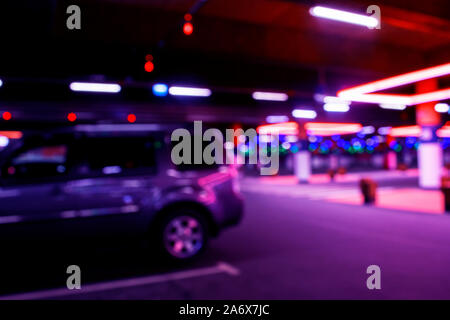 Blurred cars in car parking lot in shopping mall. Bokeh lights background. Abstract blur car parking lot for background. Blurred cars parking and boke Stock Photo