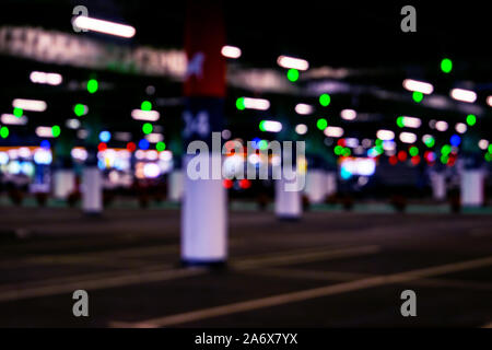 Blurred cars in car parking lot in shopping mall. Bokeh lights background. Abstract blur car parking lot for background. Blurred cars parking and boke Stock Photo