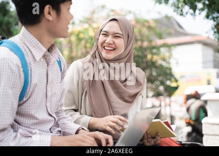asian teenage student working on an assignment while enjoying chatting together Stock Photo
