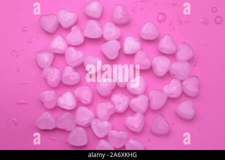 Pink abstract background of ice hearts. Love concept, modern style. Romantic card with frozen heart. Symbol of Valentine day. Cool texture, pattern. Stock Photo