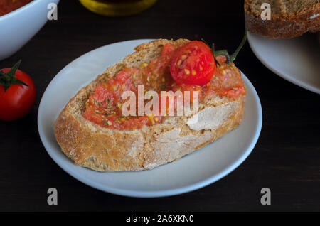 Pa amb tomaquet or tomaca (bread with tomato) also known as pan con tomate and tostada. Classic snack in Catalan cuisine, eaten for breakfast. Crusty Stock Photo