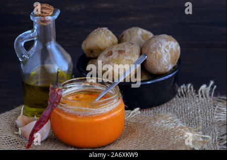 Local Canary Islands dish, Papas Arrugadas (wrinkly potatoes) with Mojo picon (red sauce). Stock Photo