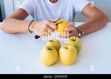 Close up of mother peeling green apples on table Stock Photo