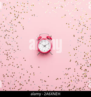 Red vintage alarm clock in the middle of pink background Stock Photo