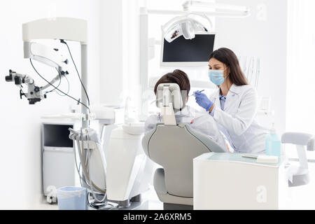 Pretty dentist doctor treating patient in dental clinic Stock Photo