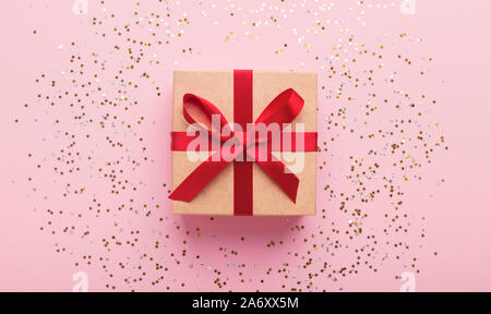 Cute present with red decorative ribbon on pink background Stock Photo