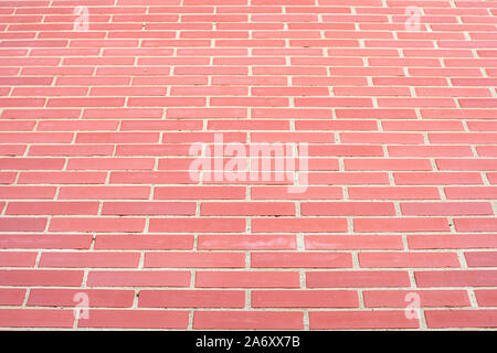Wall of bricks and cement, reddish in color, forming a high and uniform wall Stock Photo