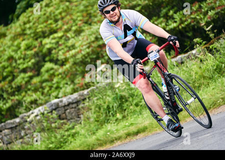 ROTHBURY, NEWCASTLE UPON TYNE, ENGLAND, UK - JULY 06, 2019: A male cyclist smiling as he rides round a corner at the cyclone race event from Newcastle Stock Photo