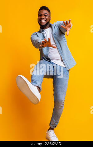 Funny black man dancing and extending his hands to camera Stock Photo
