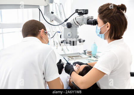 Two dentists making treatment in modern dental clinic Stock Photo