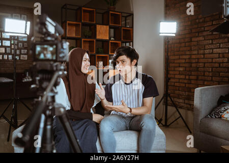 Asian muslim couple blogger recording vlog talking to camera
