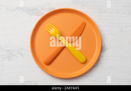 colored plastic tableware on white table Stock Photo