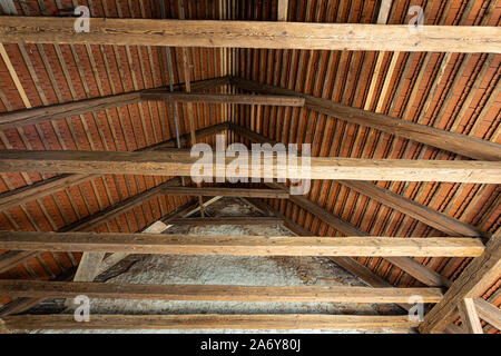 Inside an old house looking upside at the ancient wooden roof framework Stock Photo