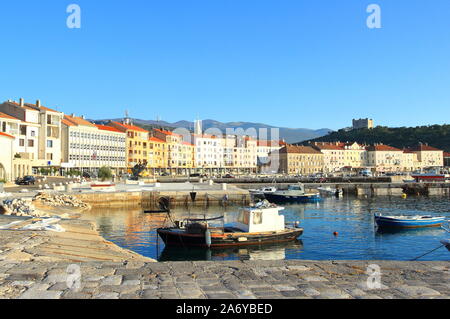 Panorama of Senj town with boats in the sea, during sunset. Nehaj fortress on the hill in background. Touristic destination in Croatia. Stock Photo