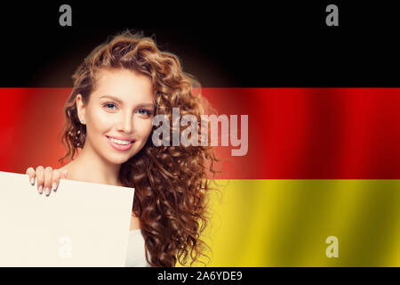 Travel in Germany concept. Pretty woman showing white background against the Germany flag background Stock Photo
