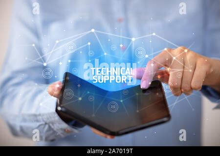 Businessman holding a foldable smartphone with TECHNICAL SUPPORT inscription, new technology concept
