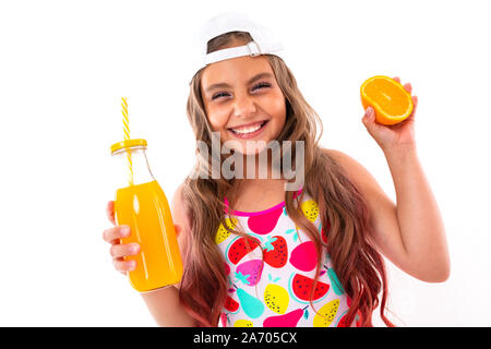 baby in a swimsuit with an orange and freshly squeezed juice in her hands smiling Stock Photo