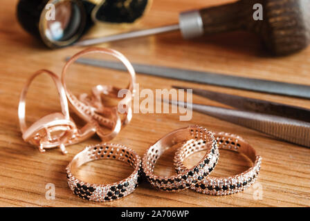 Jewelry and tools are on the table Stock Photo