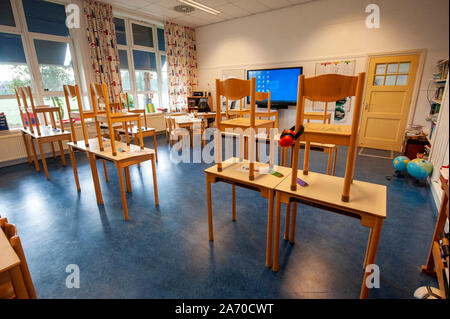 Empty schoolclass of an elementary school with chairs on the tables Stock Photo