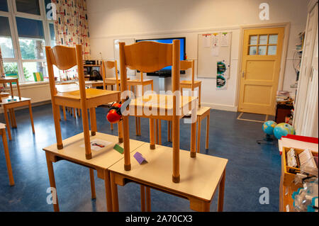 Empty schoolclass of an elementary school with chairs on the tables Stock Photo