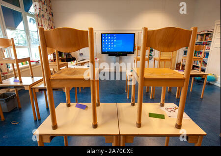 Empty schoolclass of an elementary school with chairs on the tables Stock Photo