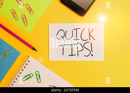 Writing note showing Quick Tips. Business concept for small but particularly useful piece of practical advice Paper sheets square notebook pencil clip Stock Photo