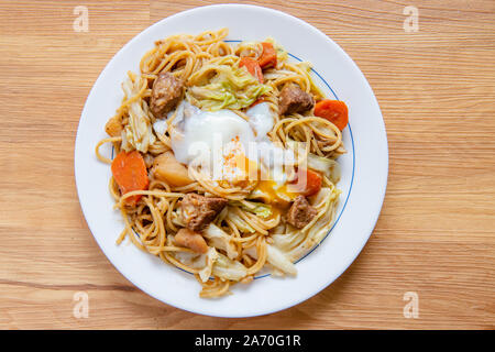 Pork Curry spaghetti  on wooden background ( Onsen tamago, Potato, enoki mushroom, onion, broccoli, Japanese style,) Stock Photo