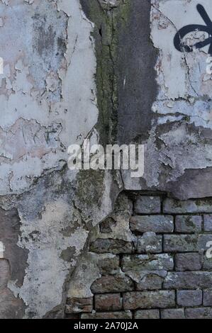 Cracked Broken Destroyed Weathered Plaster Paint on Exterior White Wall Stock Photo