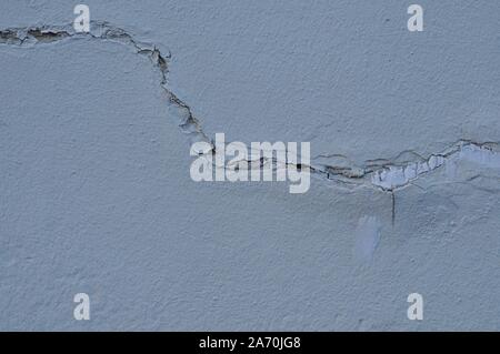 Cracked Broken Destroyed Weathered Plaster Paint on Exterior White Wall Stock Photo