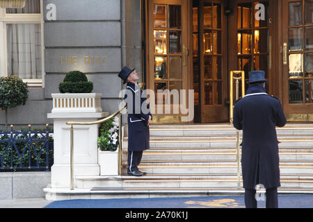 Two doorman stand outside the entrance to The Ritz Hotel on Arlington Street, Mayfair, London Stock Photo