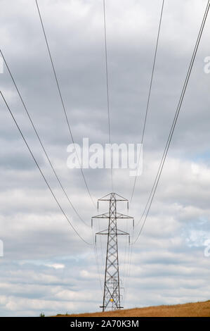 electricity pylons in Hampshire farmland crossing South Downs Way near Winchester, England. Stock Photo