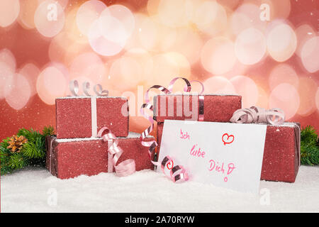 Festive gifts lie on a table with a greeting card with the inscription I love you in German Stock Photo