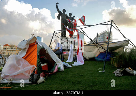 Beirut, Lebanon. 29th Oct, 2019. A demonstrator sits between tents that were destroyed by pro-Iranian Hezbollah supporters who attacked protestors in Martyr square on the 13th day of consecutive protests. Prime Minister Saad al-Hariri submits his resignation after an address to the nation. Credit: Marwan Naamani/dpa/Alamy Live News Stock Photo