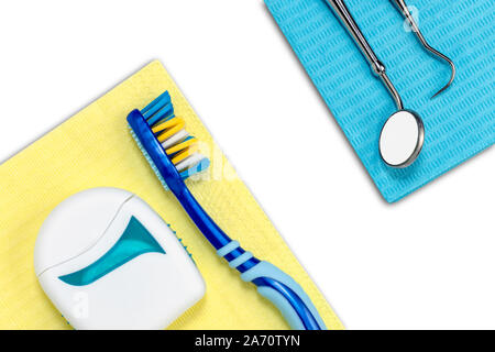 Dentist desk with toothbrush, floss, dental explorer probe and dentist mirror on white background with copy space. Flat lay composition. Stock Photo