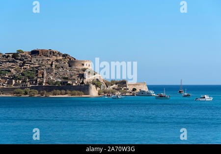 Spinalonga Island, Crete, Greece. October 2019. Ferries from Plaka and Elounda around the tiny harbour to transport tourists to visit this former lepe Stock Photo