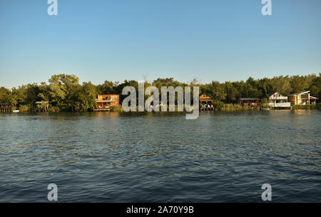 A small group of pile dwellings and cottages on the Bojana River waterfront. Stock Photo