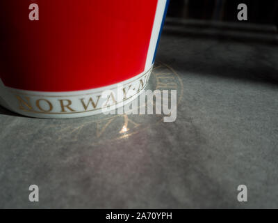 Red cup with Norwegian text reflected on the floor. Stock Photo