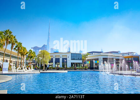Shopping center in the city with shops surrounding a swimming pool & skyscrappers in the background, Dubai, United Arab Emirates.