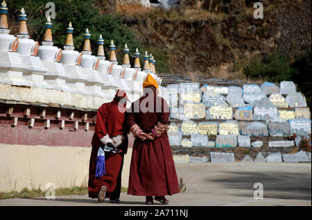 Buddhist monks walk toward the great Mani pile of Tagong in Sichuan China Stock Photo