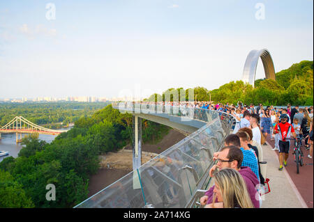 KIEV, UKRAINE - MAY 31, 2019:  Crowd of people at new Pedestrian-Bicycle Bridge at sunset. New Klitschko Pedestrian-Bicycle Bridge one of the most int Stock Photo