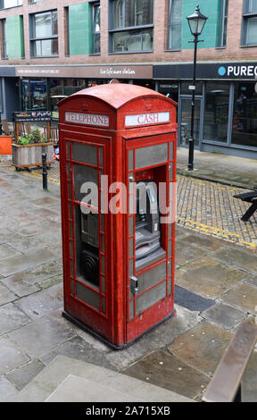 Red telephone box converted to act as a cash machine with a pay phone Stock Photo