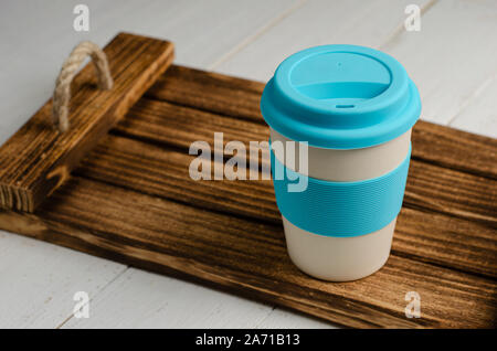 Bring your own cup. Reusable eco friendly bamboo cup for take away on wooden tray. Zero waste. Stock Photo
