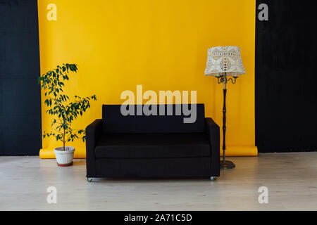 black office sofa in the interior of the yellow room Stock Photo