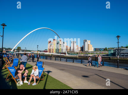 Newcastle, United Kingdom -June 27, 2019: People enjoy themselves at the river near the Gateshead Millennium Bridge and the Baltic Art Gallery Stock Photo