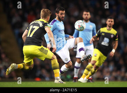 Manchester City's Bernardo Silva and Southampton's Stuart Armstrong (left) battle for the ball during the Carabao Cup, Fourth Round match at the Etihad Stadium, Manchester. Stock Photo