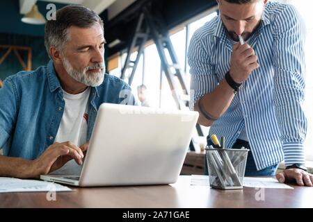 Handsome two colleagues are working in cooperation Stock Photo
